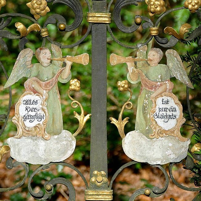 Zwei Engel aus Guss eingearbeitet in einem Zaun 